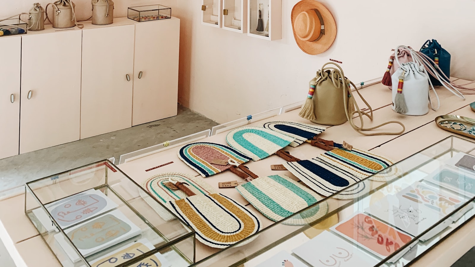 A boutique interior with woven products, leather bags, a hat on the wall, and glass display cases catching warm light — the kind of carefully curated catalog this article is about.