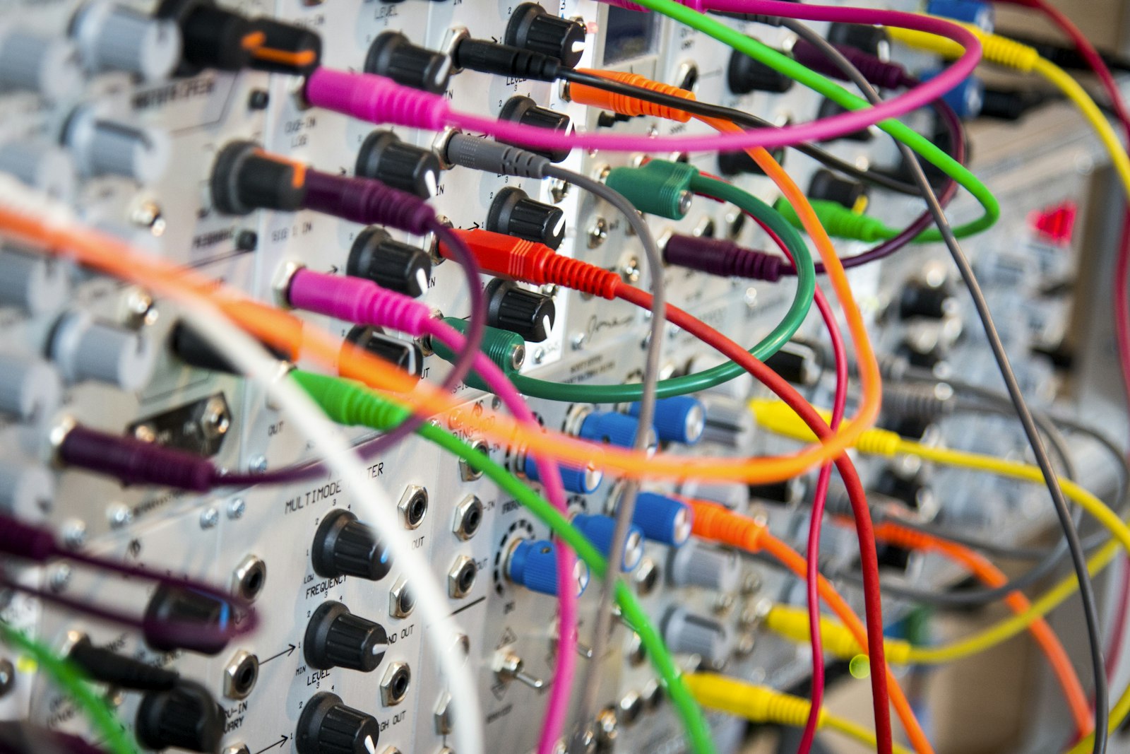 A dense bundle of assorted electric cables, twisted and tied together.
