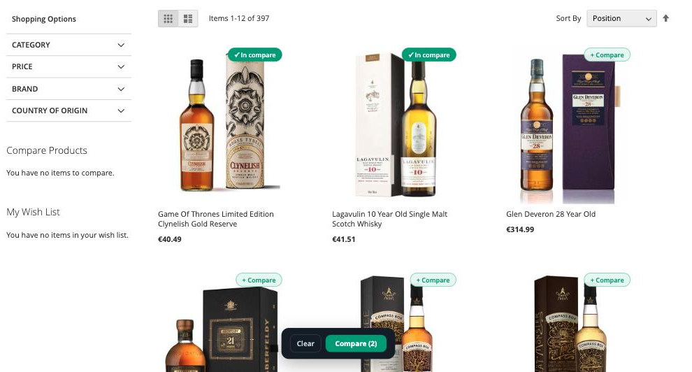 A “+ Compare” control on each tile. The shopper marks two whiskies at £40.49 and £41.51, and a bar appears to send them straight into the chat — no separate compare page.